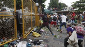 Migrantes rompen valla entre Guatemala y México y se enfrentan con la policía