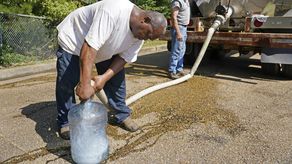 Las personas seguían haciendo filas en los centros de distribución y tiendas inundadas con el fin de conseguir agua.