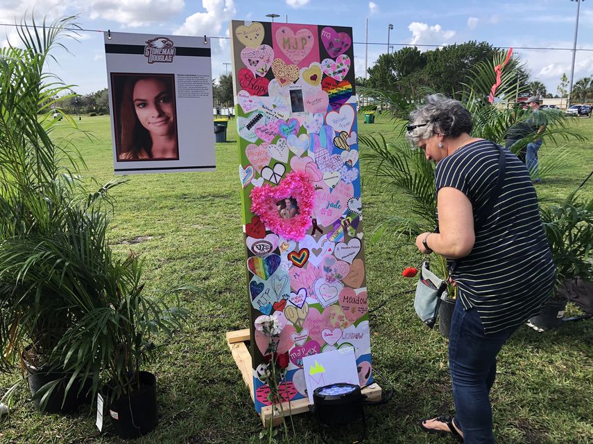 Una mujer deja un homenaje frente al memorial de una de las 17 víctimas del tiroteo en la escuela secundaria Marjory Stoneman Douglas en Parkland