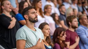 Personas&nbsp;de pie cantando el Himno Nacional más boniito según la Ai