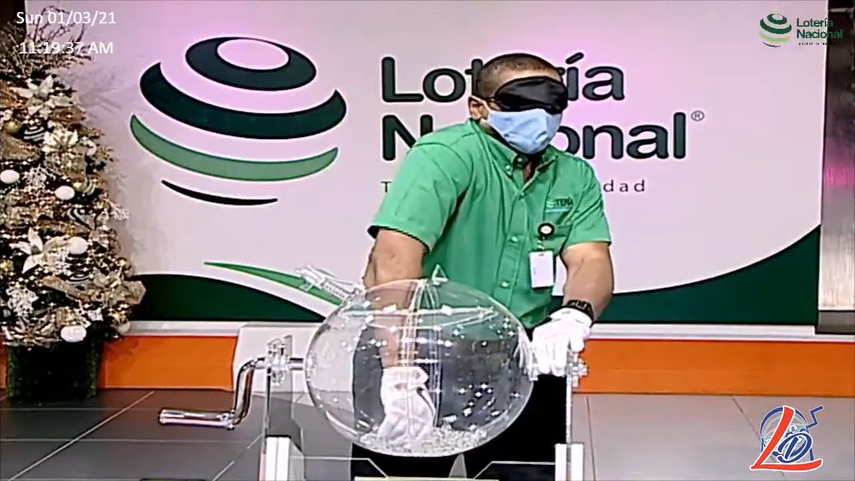 Momento en que una persona toma el número ganador de la Lotería Nacional de República Dominicana