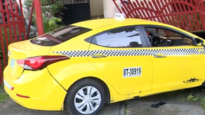 Taxi choca con el portón de una residencia.