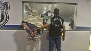 Unidad de la Policía Nacional con el aprehendido.