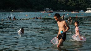 personas refrescándose en el agua en la playa de Clear Water Bay durante una ola de calor en Hong Kong.