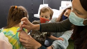 Una niña recibe una dosis de vacuna anticovid de Pfizer.