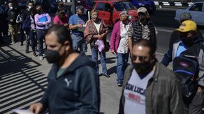 Personas hacen cola para recibir la tercera dosis de la vacuna de AstraZeneca contra el COVID-19 en un centro de vacunación para mayores de 50 años instalado en la Ciudad de México.