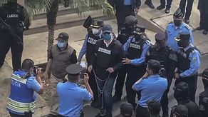 Juan Orlando Hernández es trasladado por policías.