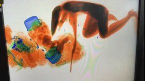 Una china se sube al escáner de control de maletas para no soltar la cartera