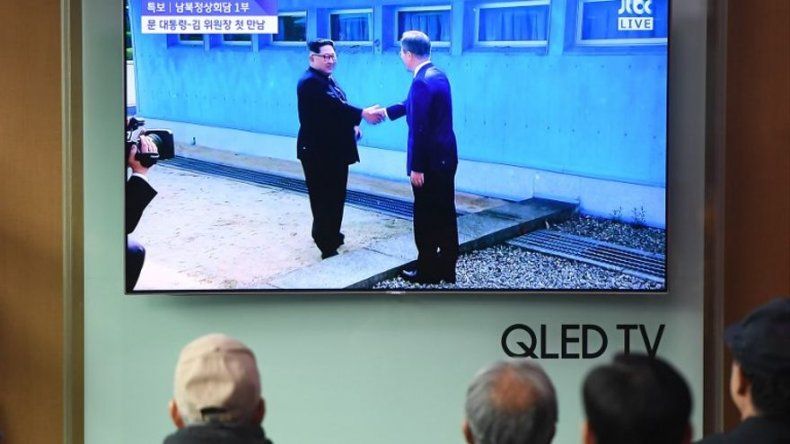 Kim y el presidente surcoreano se dan la mano en la línea de la frontera