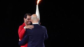 Rafael Nadal recibiendo la llama olímpica de Zinedine Zidane en la inauguración de las Olimpiadas 2024.