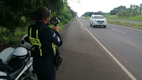 Unidad de tránsito de la Policía Nacional verificando la velocidad de un auto en la vía Unidad de tránsito de la Policía Nacional verificando la velocidad de un auto en la vía