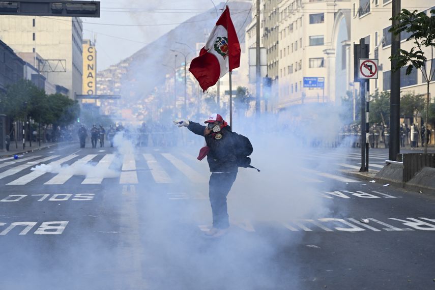 Un partidario del expresidente peruano Pedro Castillo usa una máscara para protegerse de los gases lacrimógenos durante una protesta cerca del Congreso en Lima.