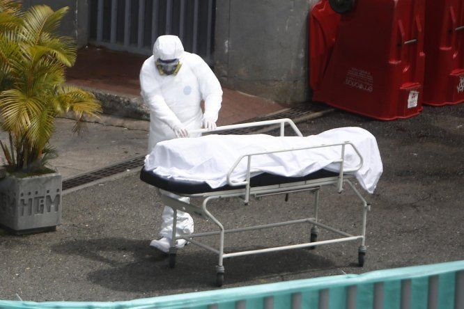 Personal sanitario transporta el cuerpo de una víctima de COVID-19