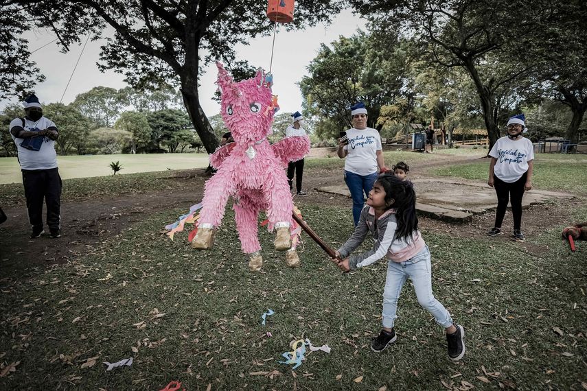 SJS01-SAN JOSÉ (COSTA RICA) 21/12/2021- Una niña rompe una piñata en una fiesta navideña para familias de exiliados, en un parque en San José, Costa Rica. Decenas de nicaragüenses exiliados en Costa Rica celebraron este viernes la Navidad con el objetivo de regresarle a los niños la ilusión de estas fiestas y con la esperanza de cambios a nivel político. EFE/Jeffrey Arguedas 