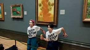 Tras lanzar la espesa sustancia, los dos activistas se arrodillaron frente a la obra y se pegaron con cola a la pared de la pinacoteca.