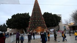 La gente mira el árbol de Navidad en la Plaza del Pesebre junto a la Iglesia de la Natividad, tradicionalmente aceptada como el lugar de nacimiento de Jesucristo, en la ciudad cisjordana de Belén.