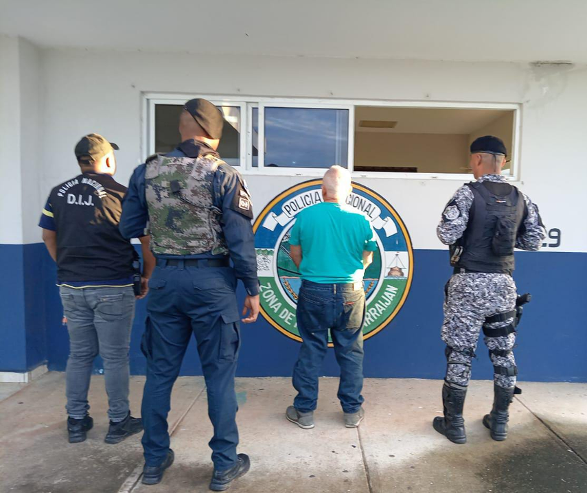 Unidades de la Policía Nacional junto a uno de los aprehendidos por estafa