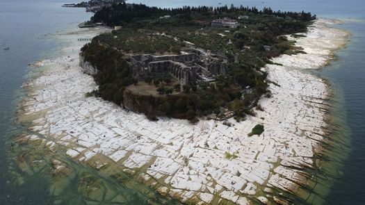 Una extensa franja de rocas blanqueadas se extendía lejos de la orilla normal.