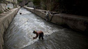 Venezolanos buscan chatarra en el río para ganarse la vida