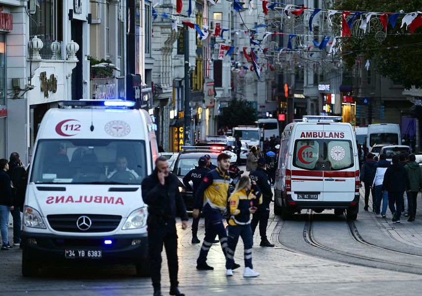 Las ambulancias se alinean mientras los policías turcos intentan asegurar el área después de que una fuerte explosión de origen desconocido sacudiera la concurrida calle comercial de Istiklal en Estambul.