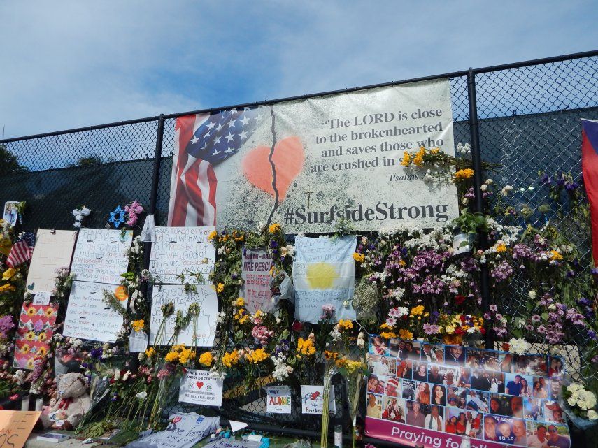 Valla dedicada a los desaparecidos en el derrumbe del edificio de condominios de 12 pisos en Surfside