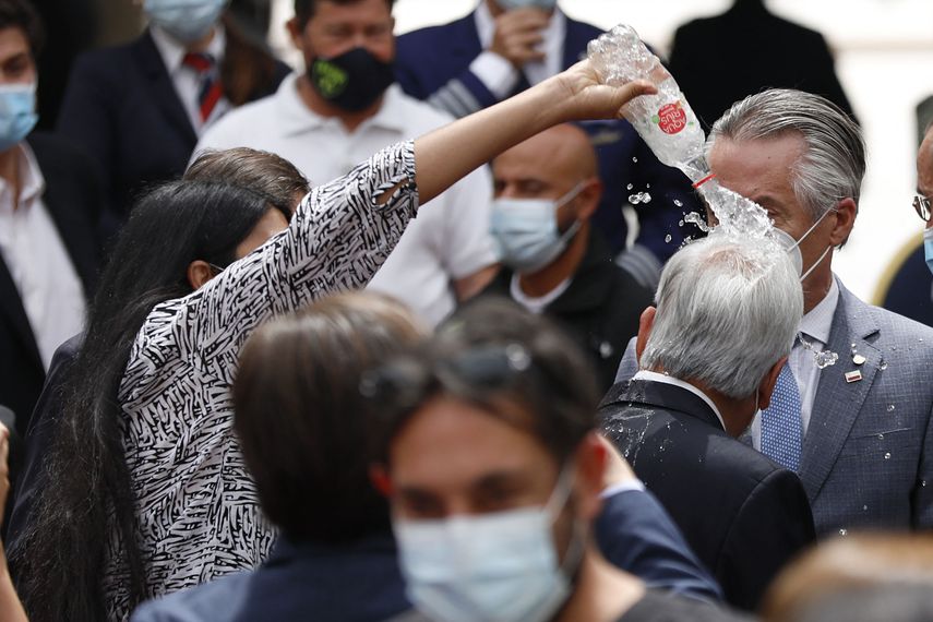 Momento en el que una mujer tira agua al presidente de Chile
