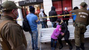 Fotografía de archivo fechada el 30 de julio de 2020, que muestra a un grupo de personas mientras esperan, custodiados por la policía, para realizar los trámites de retiro anticipado del primer 10% de sus fondos de pensiones.