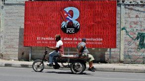 Dos personas pasan hoy frente a una valla que promociona el VIII Congreso del Partido Comunista de Cuba (PCC), a celebrarse del 16 al 19 de abril en La Habana.