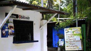 Una tienda cuelga carteles que ofrecen servicio en bitcoin en la playa El Zonte, en Chiltiupan, El Salvador.