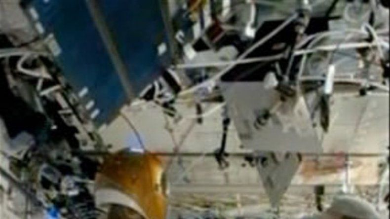 Humano y robot humanoide se saludan de mano en estación espacial