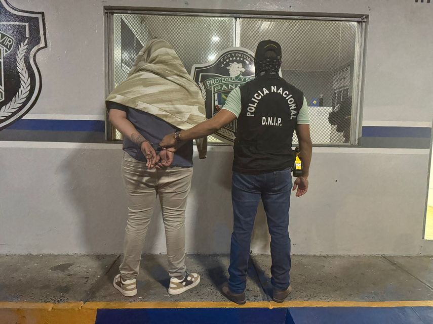 Unidad de la Policía Nacional con el aprehendido.