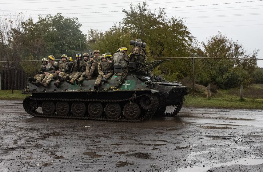 Los militares ucranianos se paran en un transporte personal blindado cerca de Borivske
