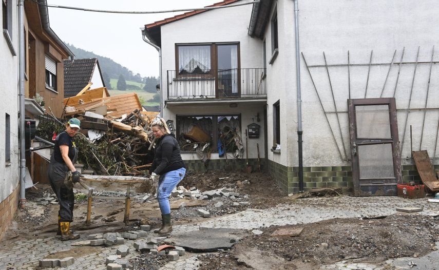 Residentes sacan sus pertenencias destruidas de una casa después de que las inundaciones causaron daños importantes en Schuld