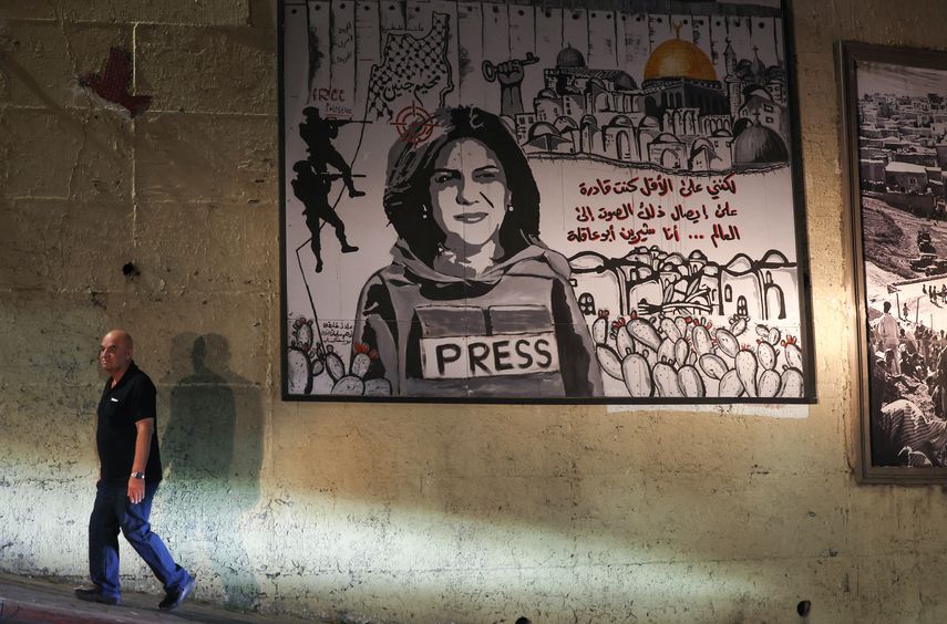 Un mural que representa a la periodista palestino-estadounidense asesinada Shireen Abu Akleh se ilumina con faros en una calle de la ciudad árabe de Umm Al-Fahm