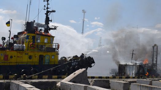 Bomberos ucranianos luchando contra un incendio en un barco que ardía en el puerto de Odesa después de que los misiles impactaran en el puerto.