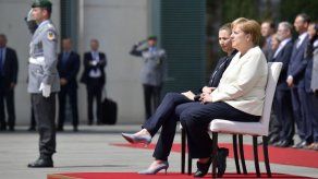Merkel participa sentada en honores militares para evitar un nuevo temblor
