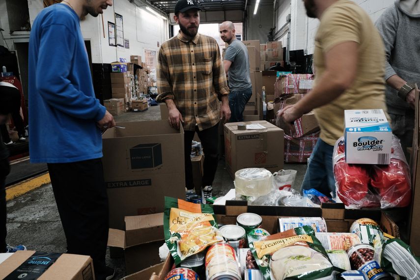 Estadounidenses ucranianos y otros preparan cajas de ayuda en un garaje de automóviles para enviarlas a Ucrania.