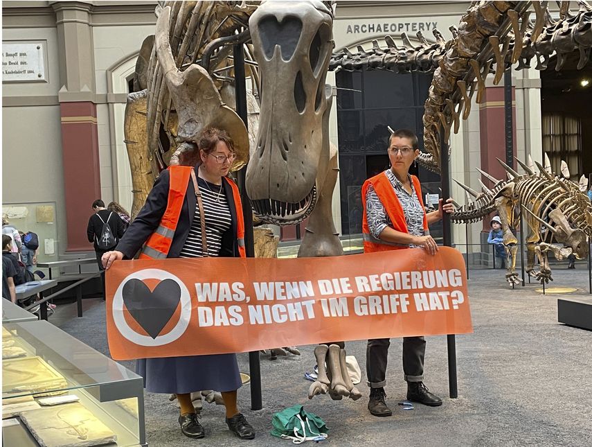 Activistas se pegan a esqueleto de dinosaurio como protesta