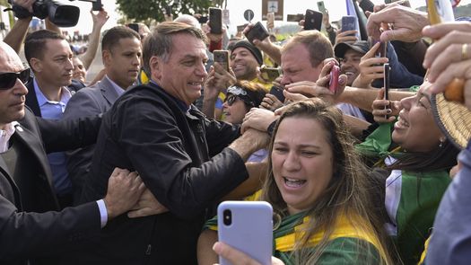 El presidente brasileño, Jair Bolsonaro, saluda a sus seguidores durante un mitin en el aeropuerto de Serrinha, en Juiz de Fora.