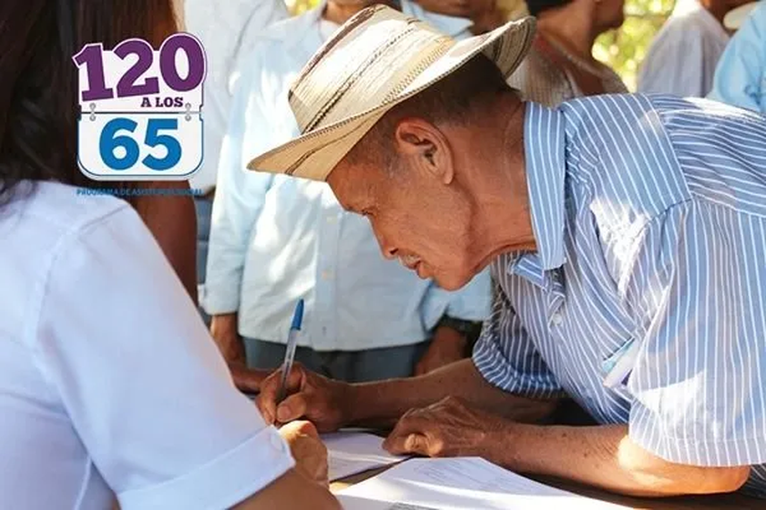 Adulto mayor firmando para recibir el pago del programa 120 a los 65 Adulto mayor firmando para recibir el pago del programa 120 a los 65