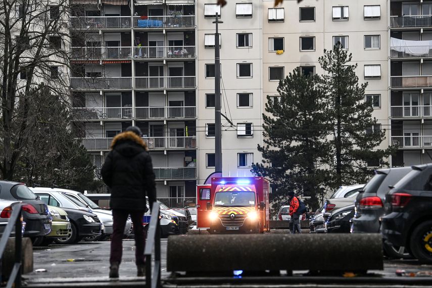 Un vehículo de bomberos está estacionado afuera de un edificio de apartamentos de siete pisos donde cinco niños