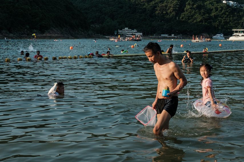 personas refrescándose en el agua en la playa de Clear Water Bay durante una ola de calor en Hong Kong.