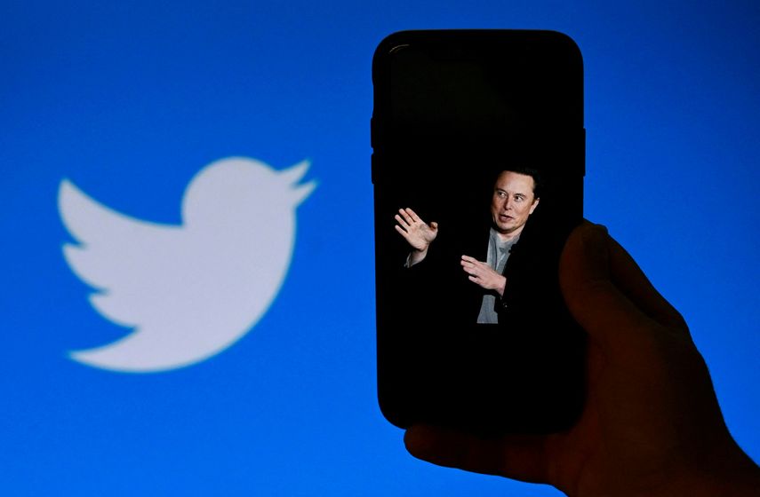 Pantalla de un teléfono muestra una foto de Elon Musk con el logotipo de Twitter en el fondo.