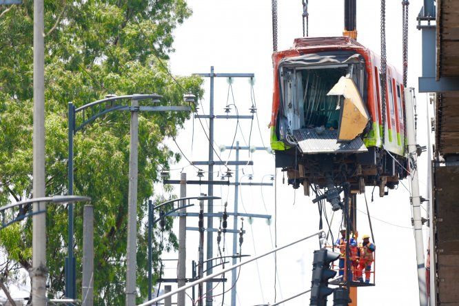 En la mañana de este martes operarios retiraban los cuerpos que quedaron atrados entre los restos del metro de México colapsado.