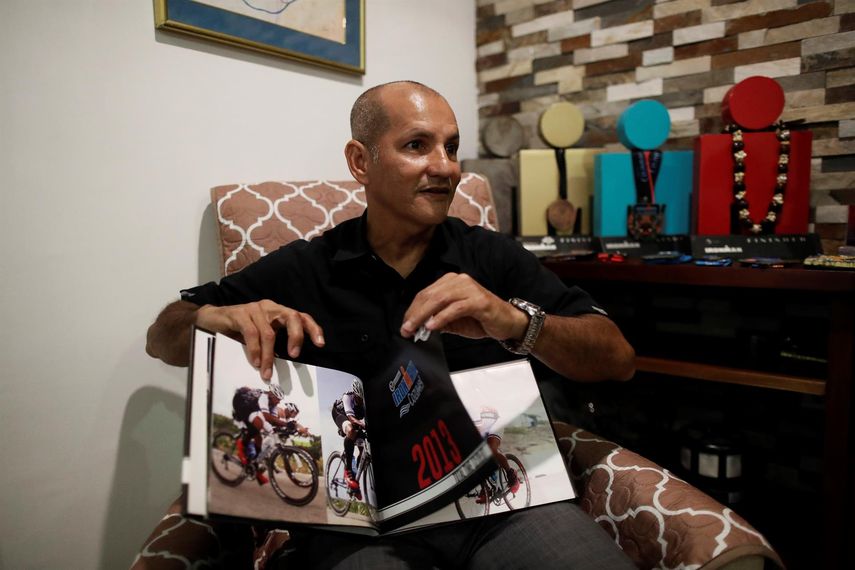 El triatleta panameño Eladio Quintero muestra un libro a EFE durante una entrevista sobre su trayectoria deportiva.