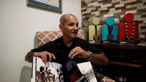El triatleta panameño Eladio Quintero muestra un libro a EFE durante una entrevista sobre su trayectoria deportiva.