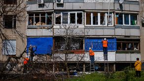 Los lugareños intentan arreglar las ventanas de un edificio residencial que resultó dañado por los bombardeos rusos en Kharkiv, en el este de Ucrania.