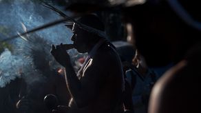 Un hombre de la tribu Kambiwa de Pernambuco fuma una pipa durante un ritual tradicional en un campamento de protesta indígena.
