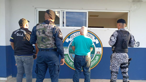 Unidades de la Policía Nacional junto a uno de los aprehendidos por estafa