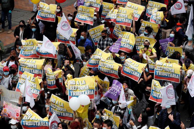 Decenas de personas entre las que sobresalen carteles de protesta participa en la jornada de manifestaciones denominada Paro Nacional